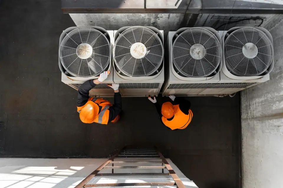 Technicians working on HVAC system equipment